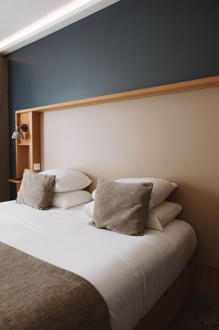Beautifully made bed with neutral linen